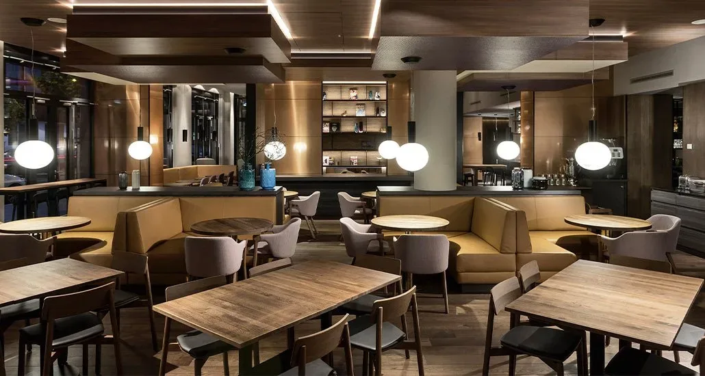 Here we see a different view of the Loden dining armchair, also in a restaurant with round and square dining tables
