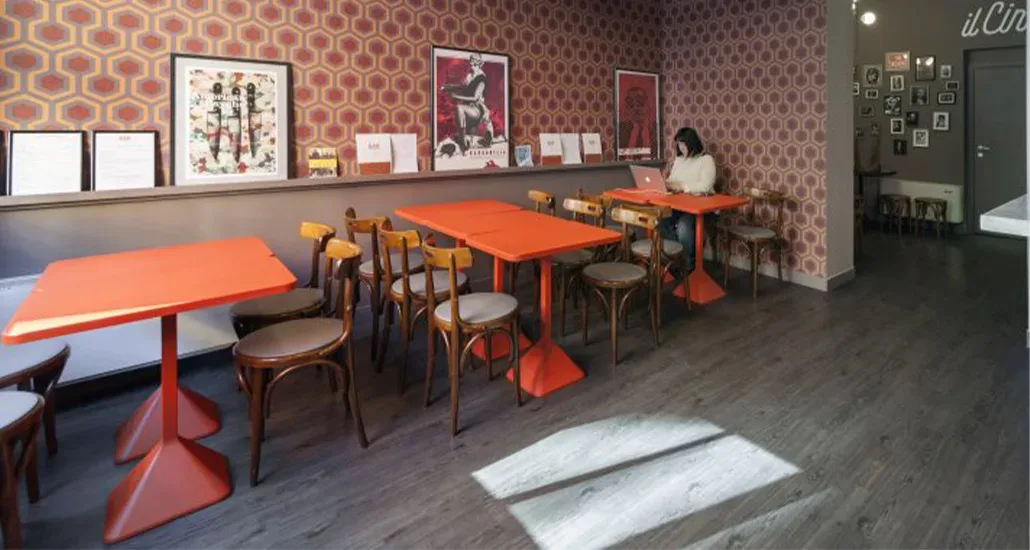 a restaurant setting with the tnp table - a square dining table with bright colors and dining chairs around it