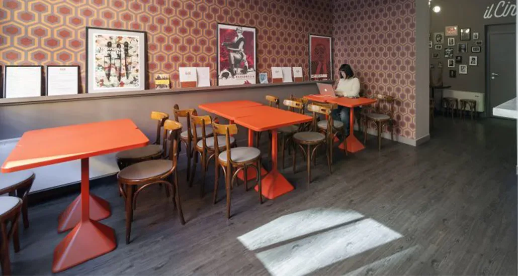 A restaurant setting with The TNP table - a square dining table with bright colors and dining chairs around it