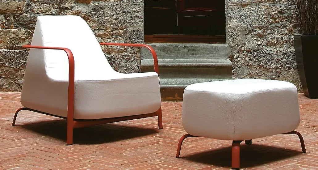 the bigfoot armchair next to a pouf