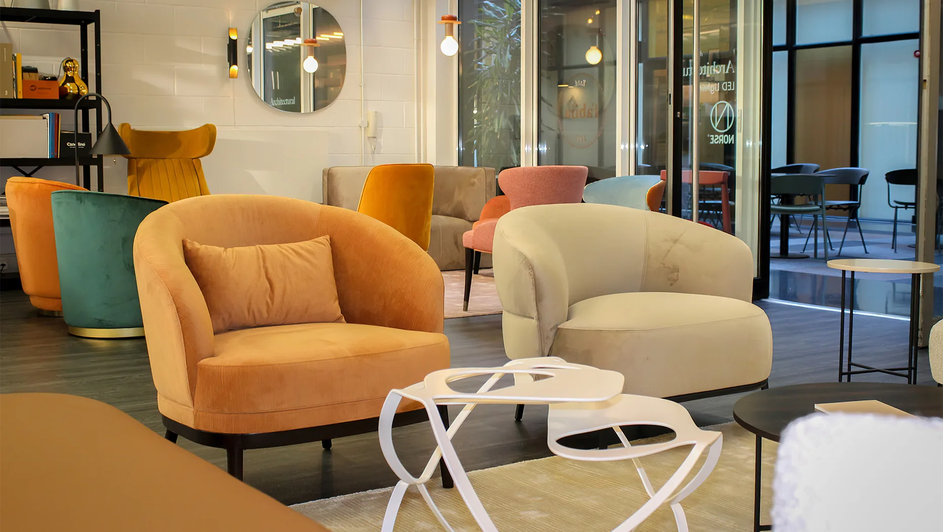 a display of cozy lounge armchairs with plush upholstery and a back cushion, as well as a round coffee table in the front