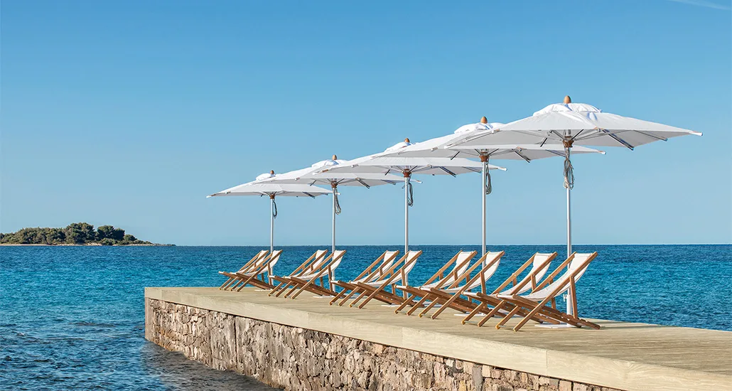 free parasol by ethimo is a contemporary outdoor polyester umbrella with aluminium stand and is suitable for hospitality projects