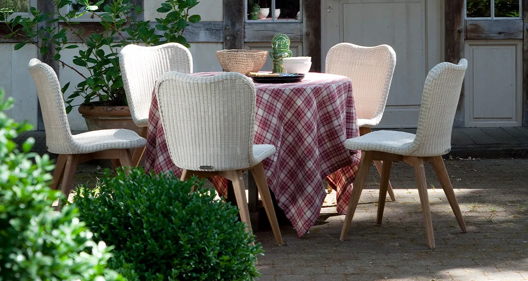 Lena dining chair is a contemporary outdoor dining chair with wicker and steel seat and wood base is suitable for hospitality and contract projects.