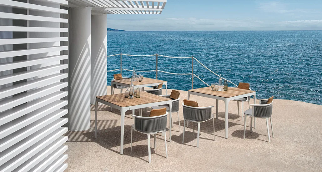 Nicolette dining armchair is a contemporary aluminium and teak outdoor dining armchair and is suitable for contract and hospitality spaces.