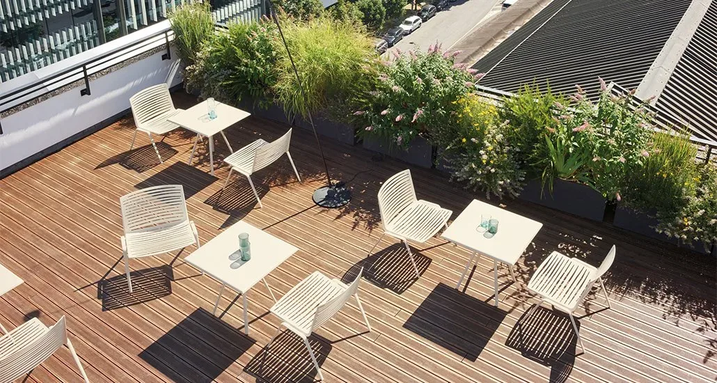 a top view of a few zebra lounge in shades of white armchairs on a deck