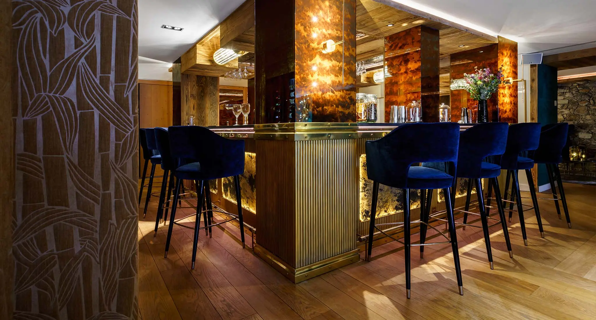Blue chairs with gold accents arranged in a bar at LA SIVOLIÈRE hotel in France, showcasing the supplied furniture's elegant design.