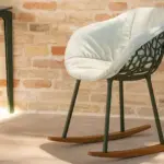 Forest Rocking Armchair is contemporary outdoor rocking armchair with aluminium frame and wood base and is placed in a contract hospitality outdoor space.